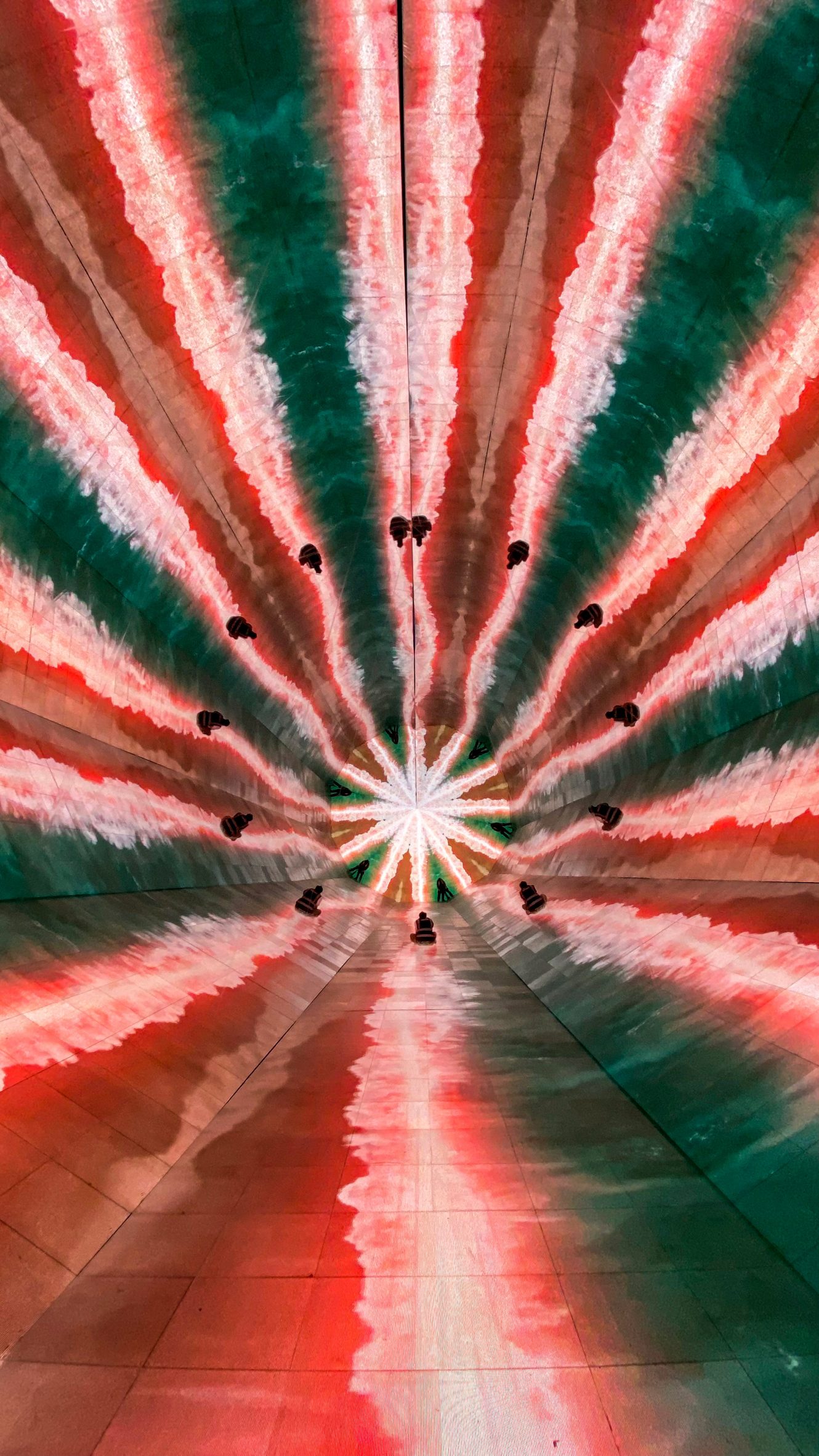 Abstract red and green imagery shows within a giant kaleidoscope