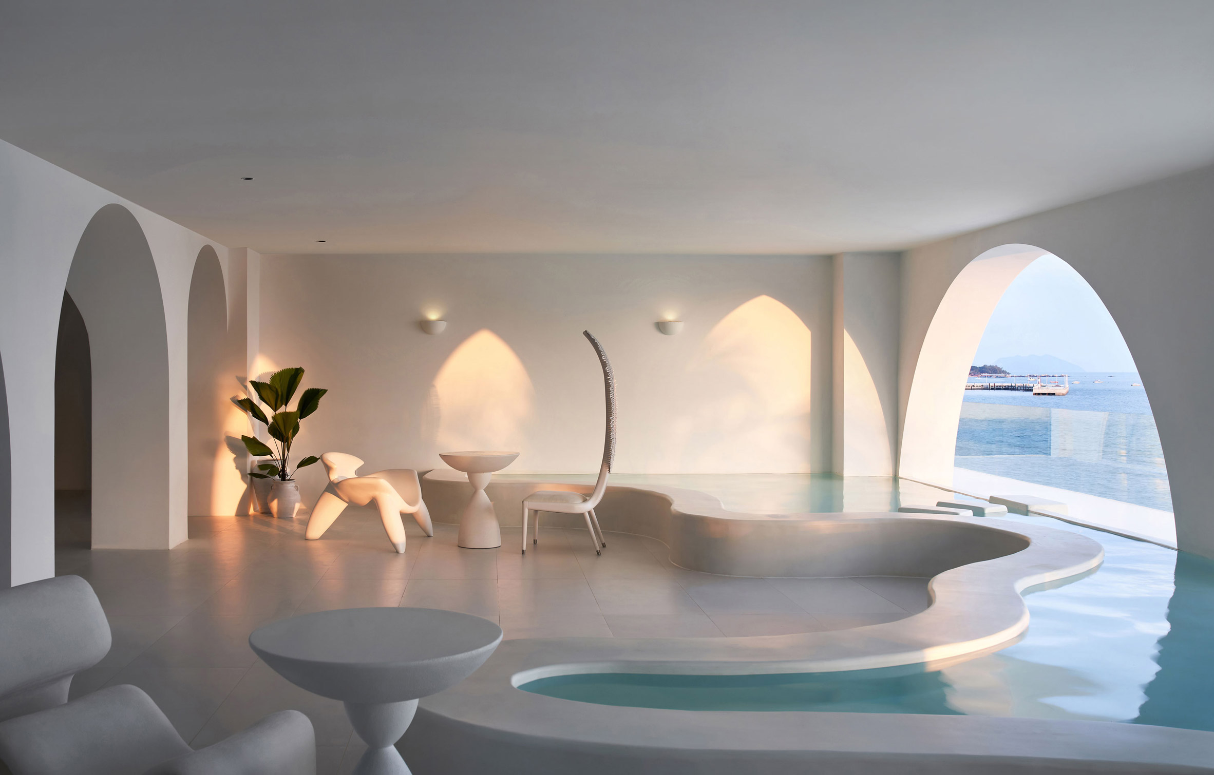 Hote lounge by GS Design with curvy-edged pool and white furniture