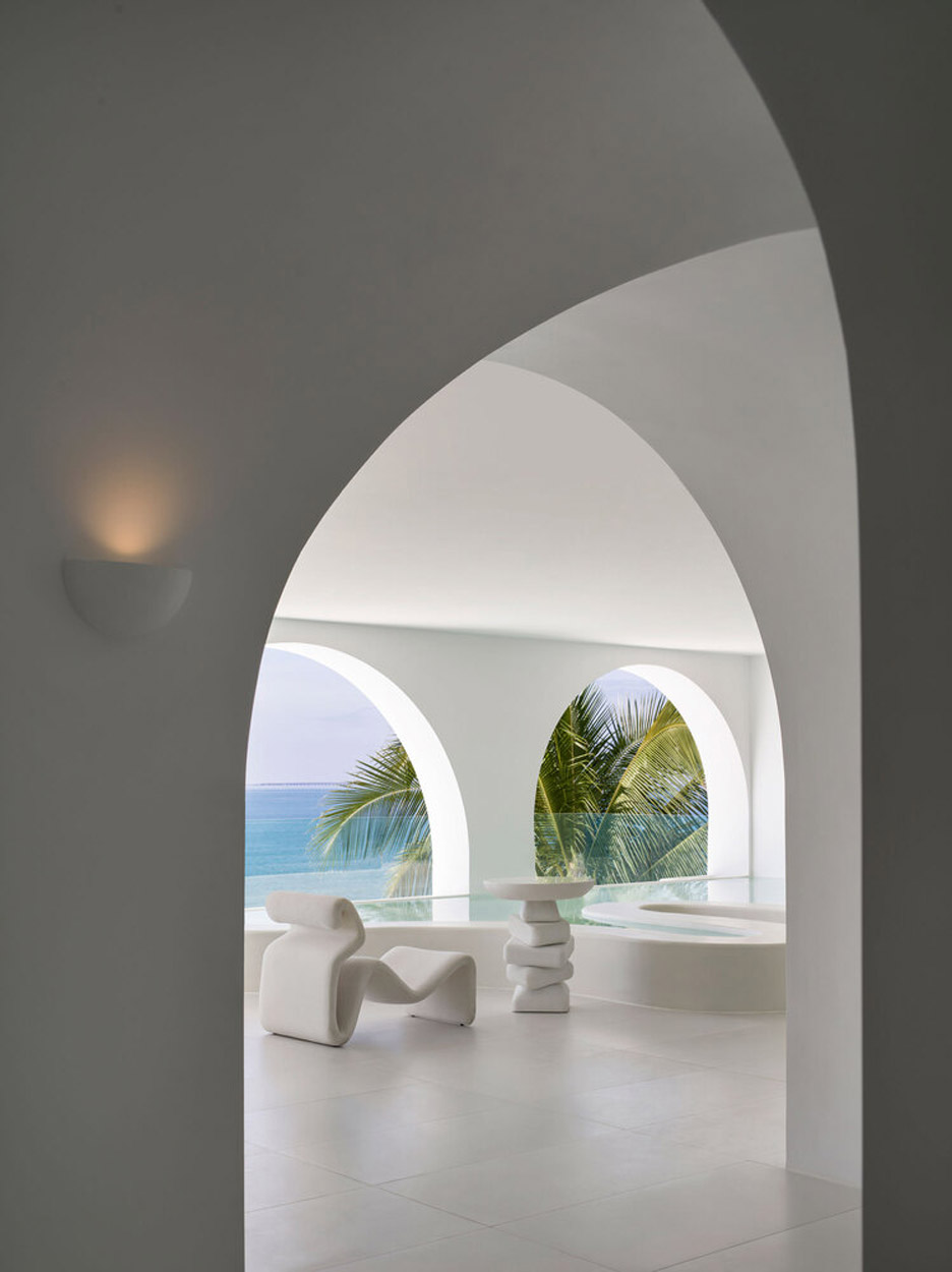 Sculptural white armchair and table in white room at Sumei Skyline Coast hotel by GS Design