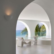 Sillón y mesa blancos escultóricos en una habitación blanca en el hotel Sumei Skyline Coast de GS Design