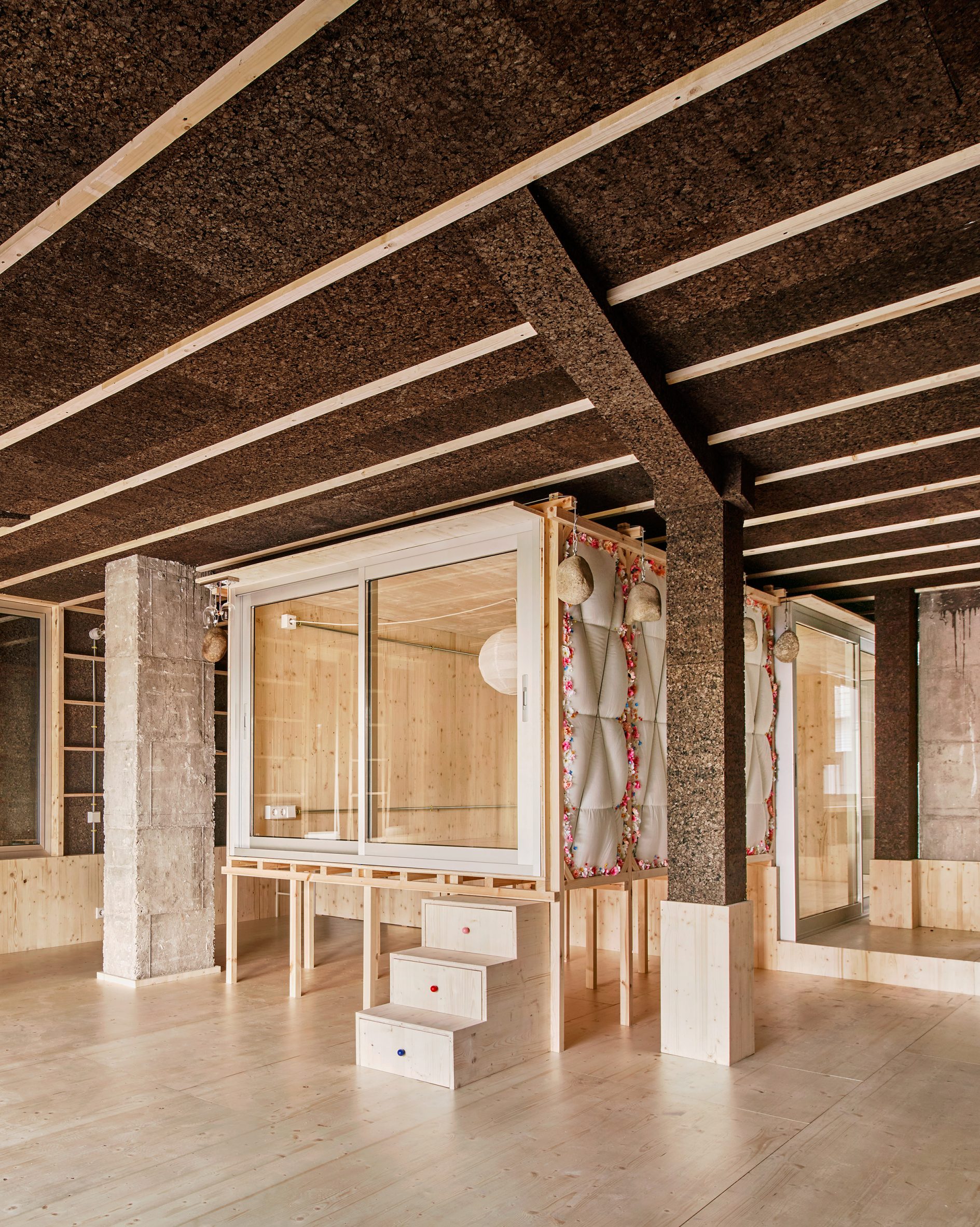Bedroom in a wooden box raised on stilts in a cork-clad apartment by Takk