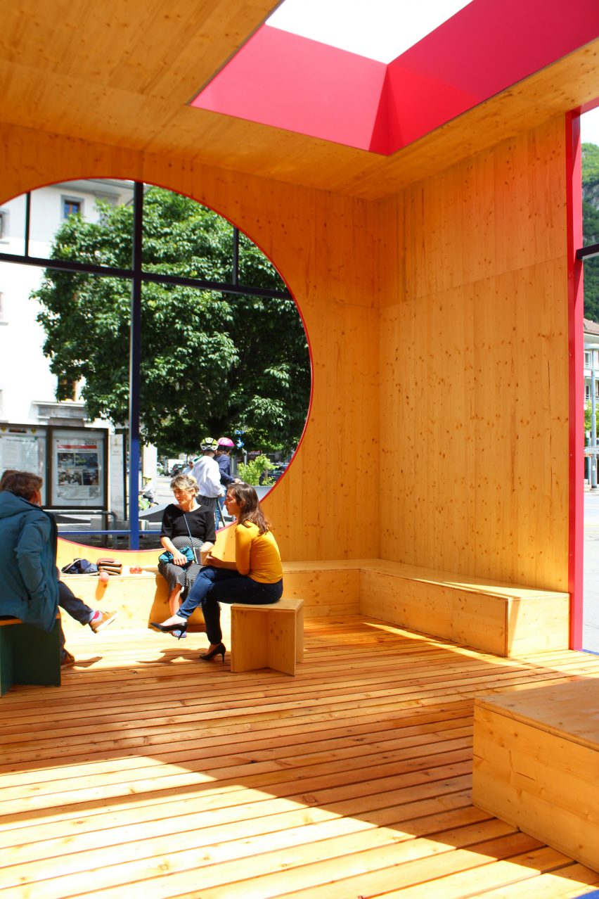 Adults sitting inside a wooden pavilion