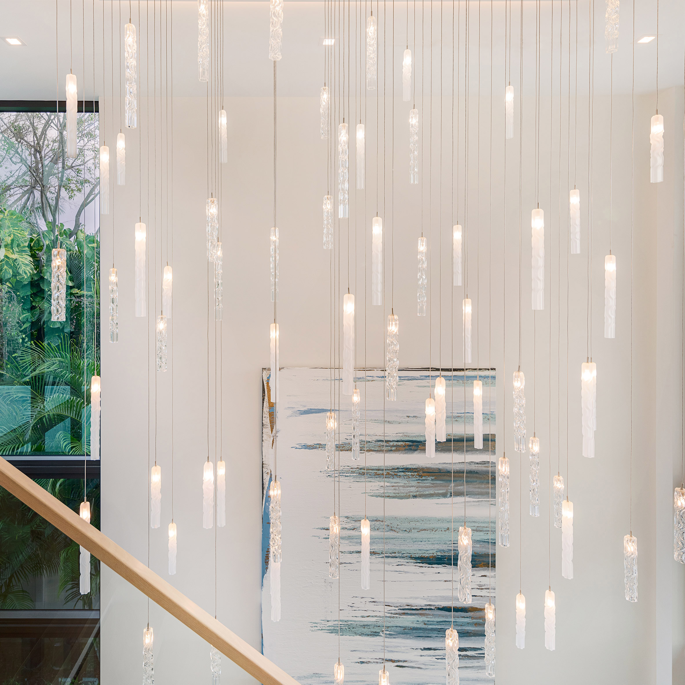 A constellation of Twist pendant lights by Dedar hung in a staircase