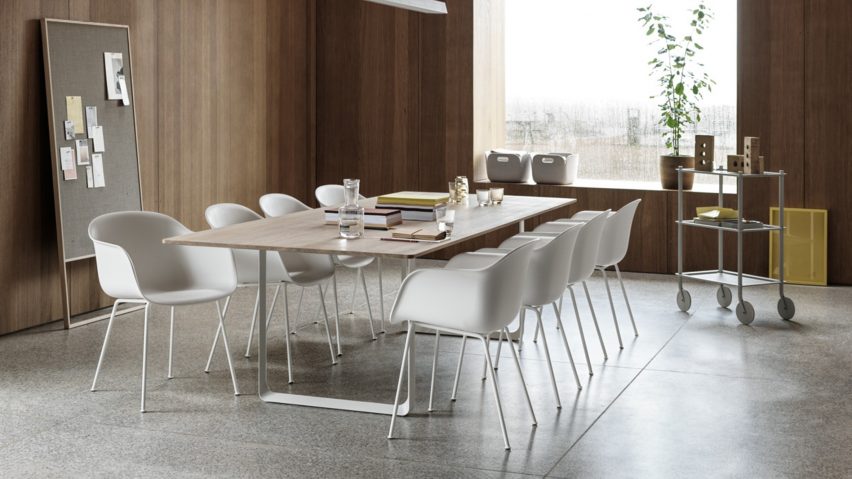 A series of Muuto Fiber Chairs in solid oak white surround a Muuto table