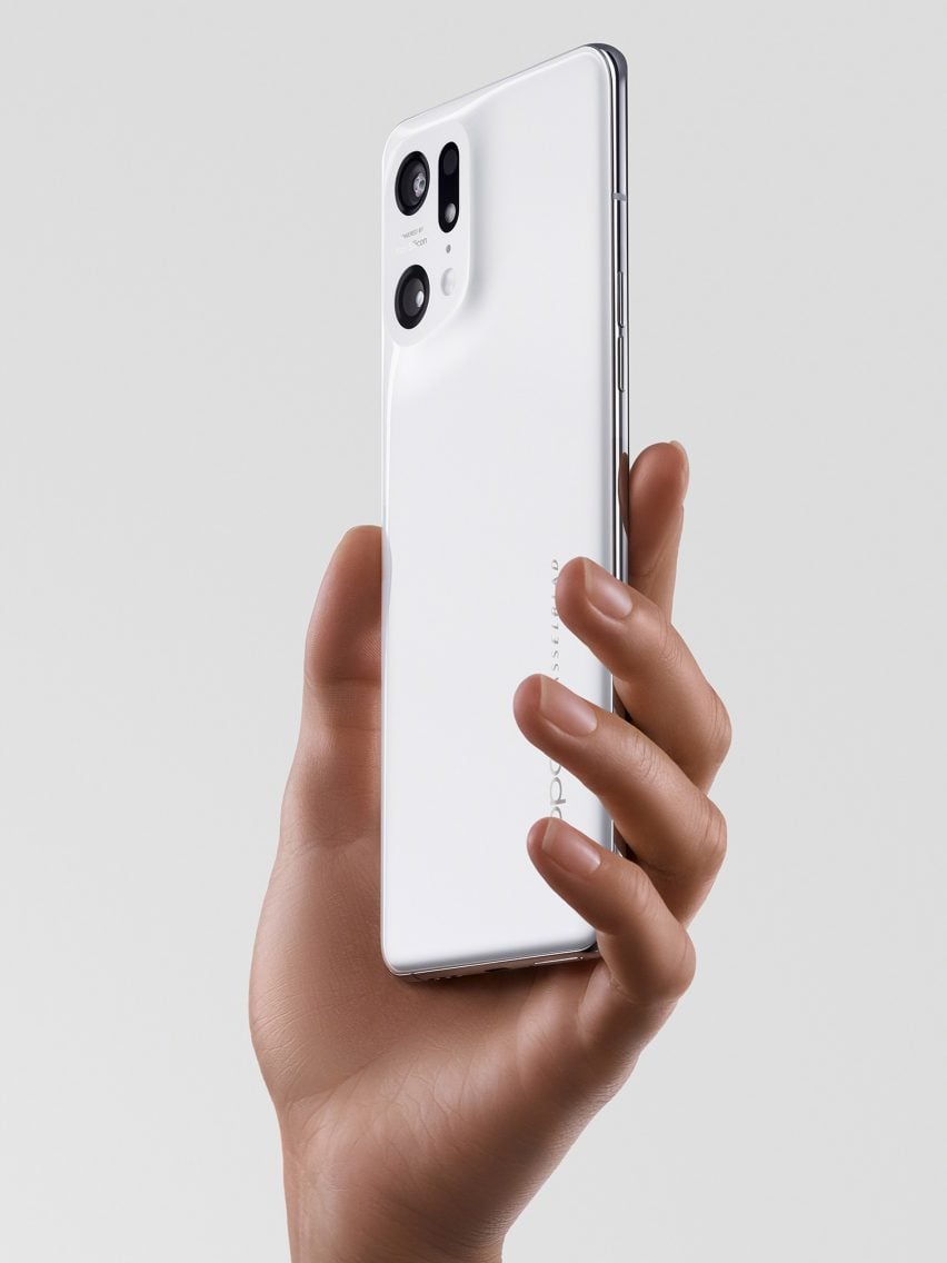 A photograph of a person's hand holding a white OPPO phone