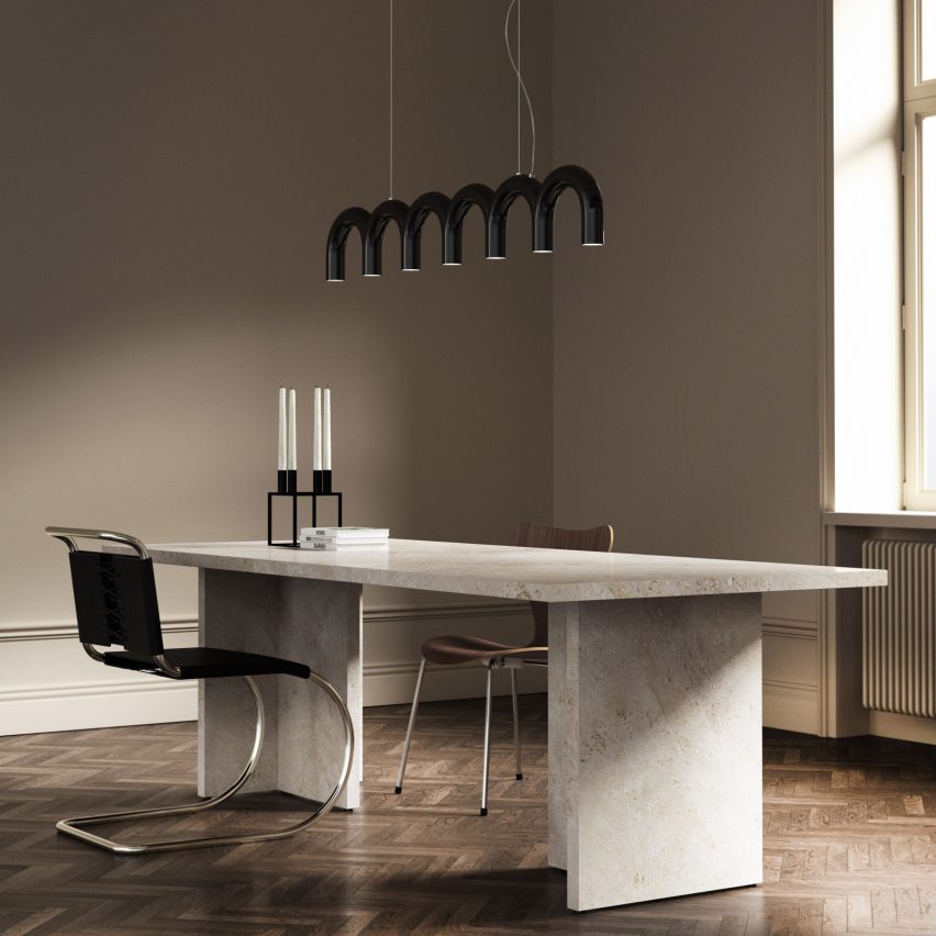 A photograph by Arch pendant by Oblure in black over an office desk 