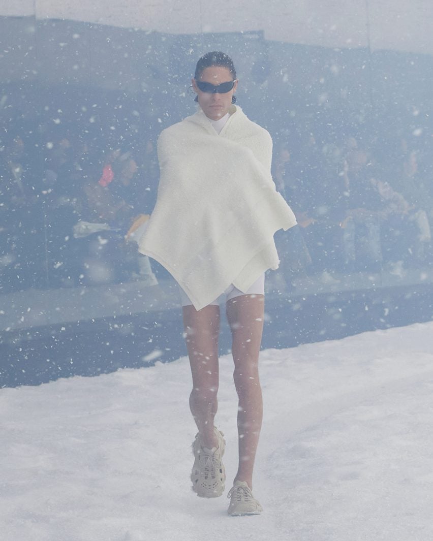 Model walking through the blizzard wrapped in an off-white towel