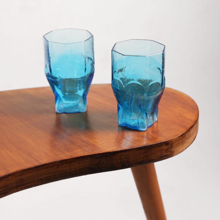 Two blue tumbler glasses on a wooden table