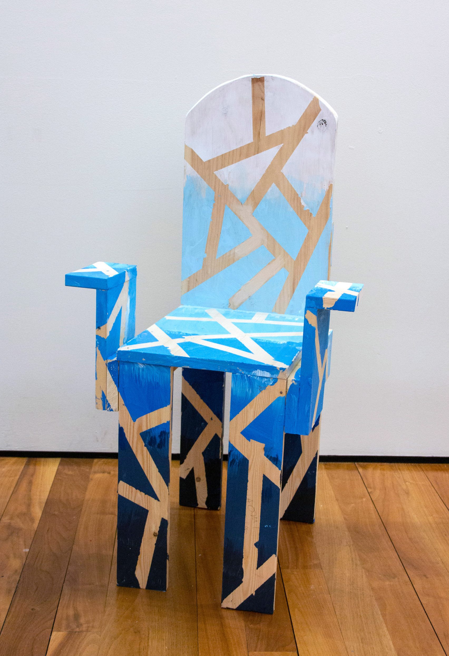 Child-made chair painted in modulations of light to dark blue, with crisscross pattern created by removing masking tape