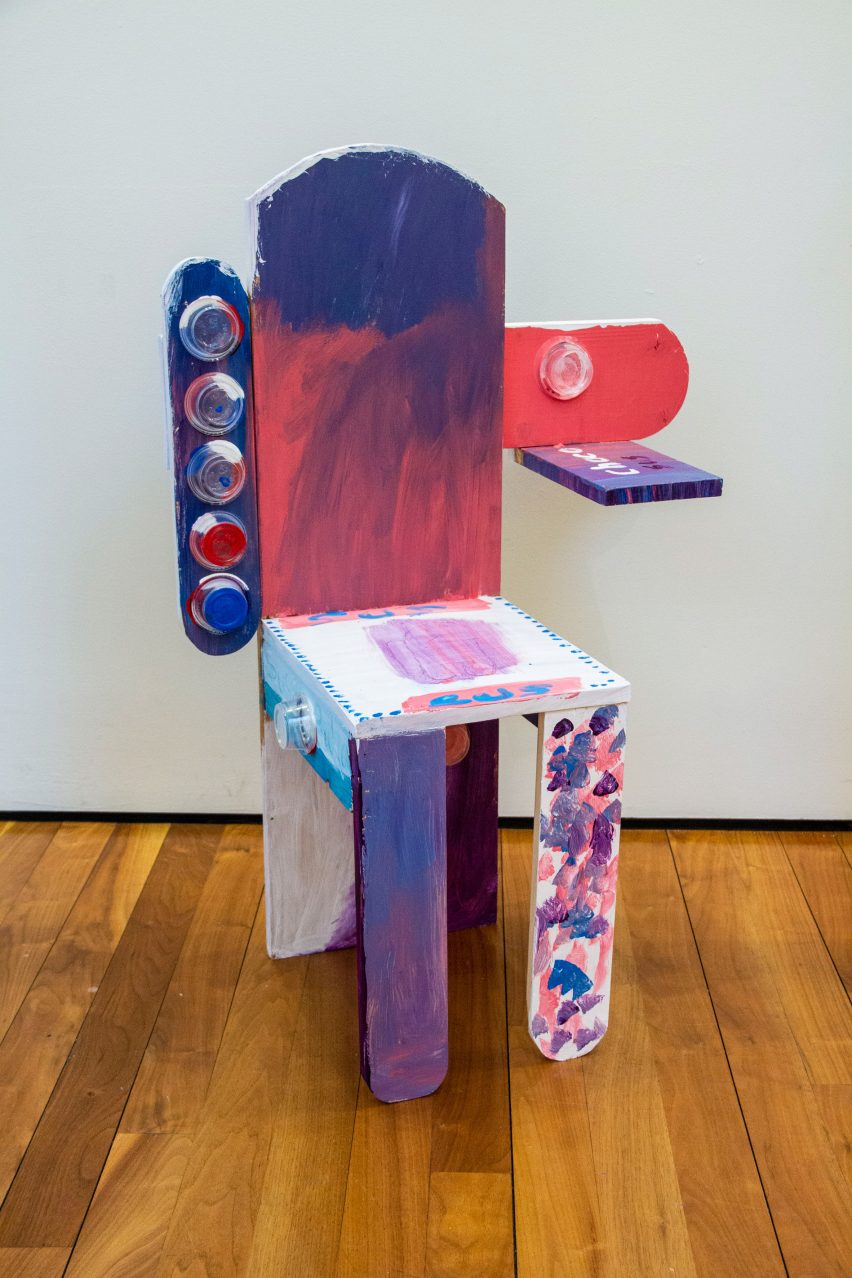 Child-made chair with small table, painted pink, purple and white with glued plastic containers