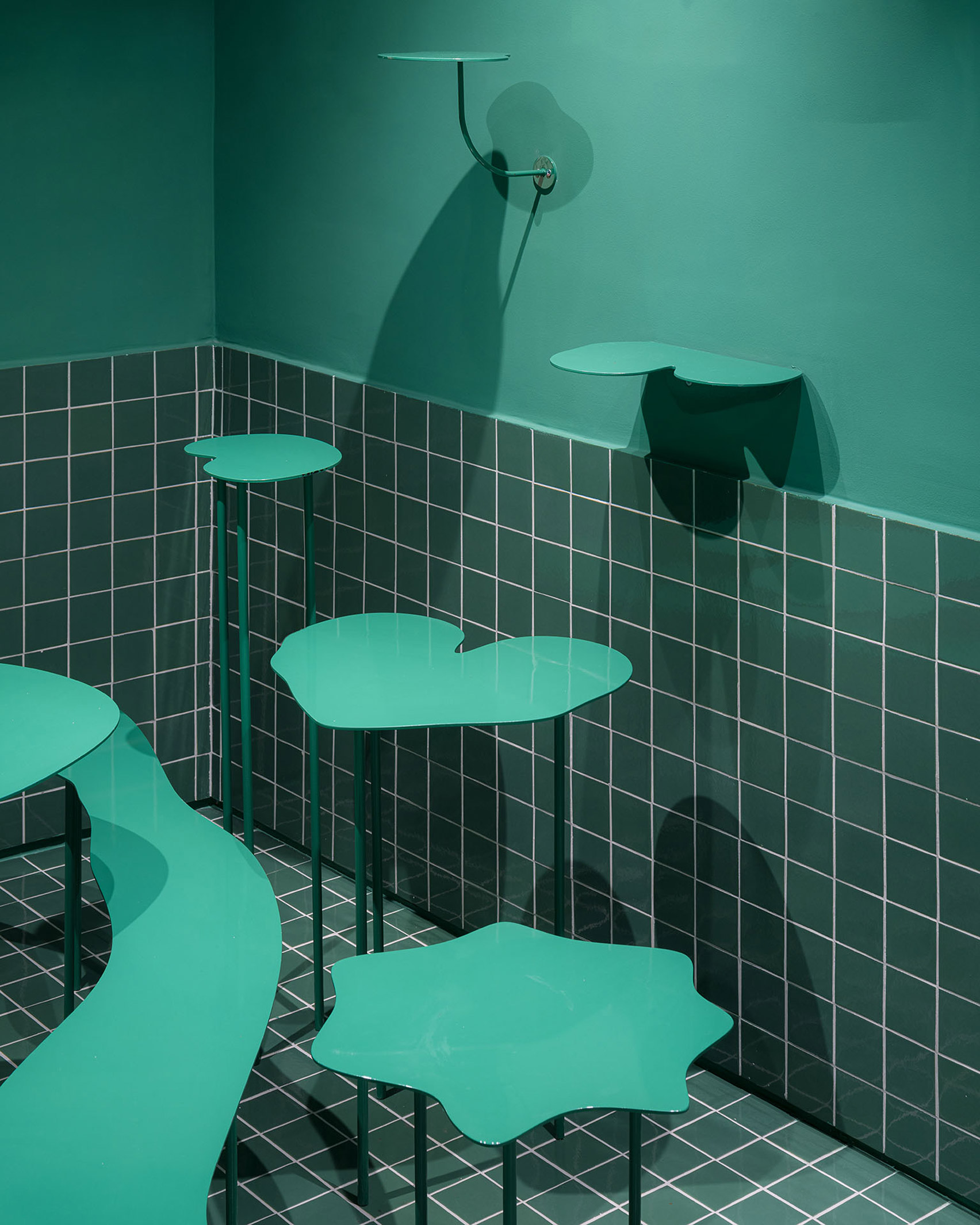 Wiggly edged sea green furniture in colour-block interior of bakery designed by Case Antillón