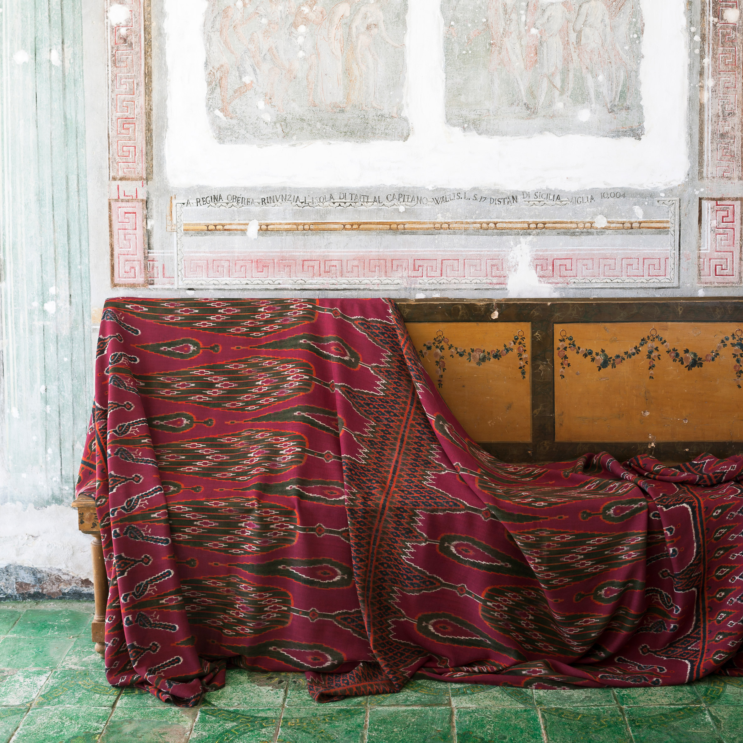 A photograph of the Paradiso Paisley in red, draped over a piece of furniture
