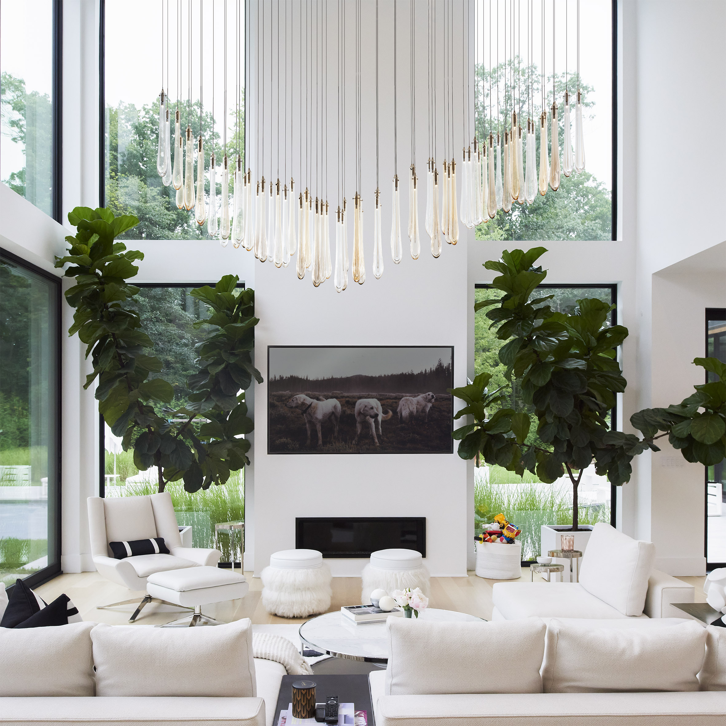 Dew pendant lights hung as a chandelier in a large white living room with tall ceilings
