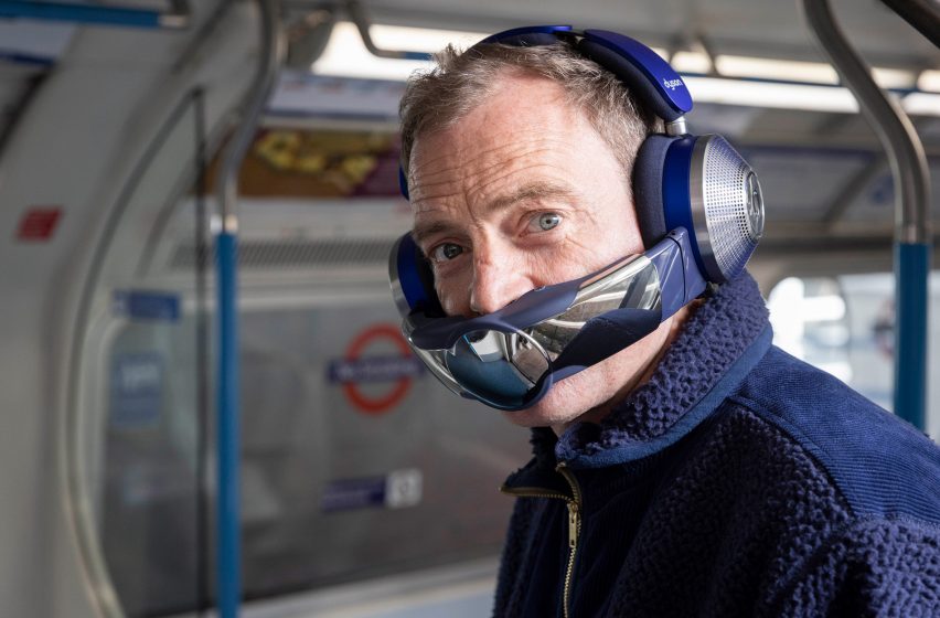 A man wearing headphones and a visor on public transport