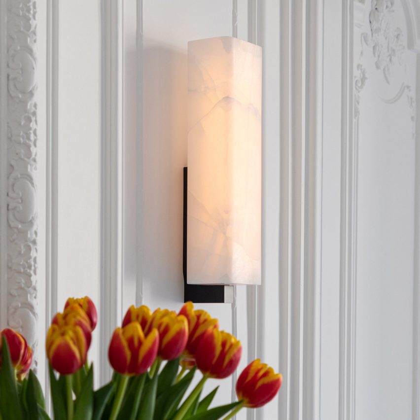 Embrun wall light by Ozone on panelled white walls with red tulips