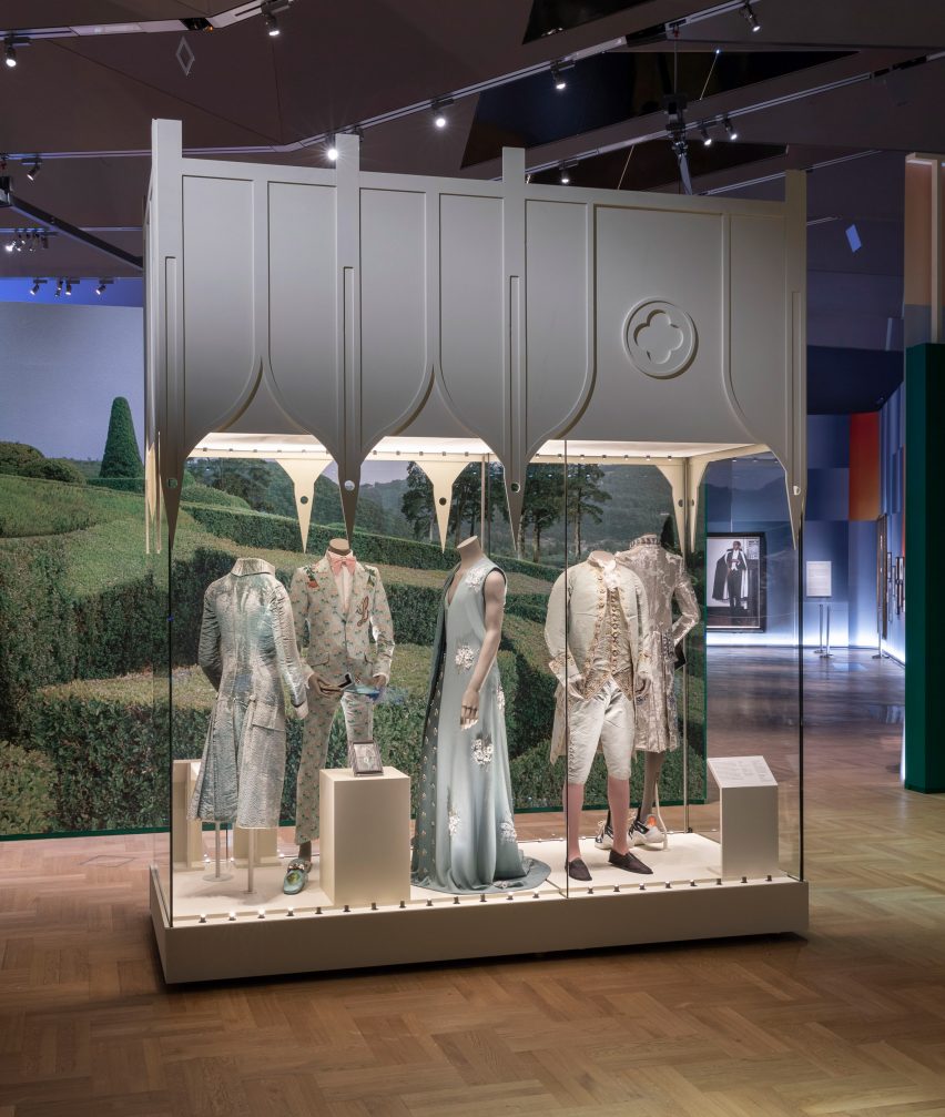 Glass vitrine with pastel hued clothing at Fashioning Masculinities: The Art of Menswear