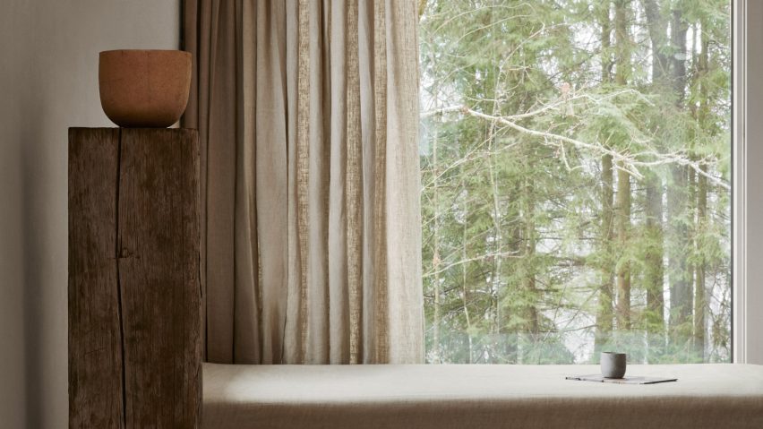 Window seat next a plinth holding a ceramic vessel in Swedish forest retreat designed by Norm Architects