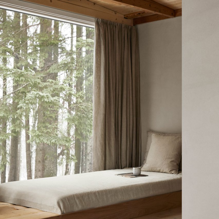 Asiento junto a la ventana en los interiores minimalistas de un refugio forestal en Suecia diseñado por Norm Architects