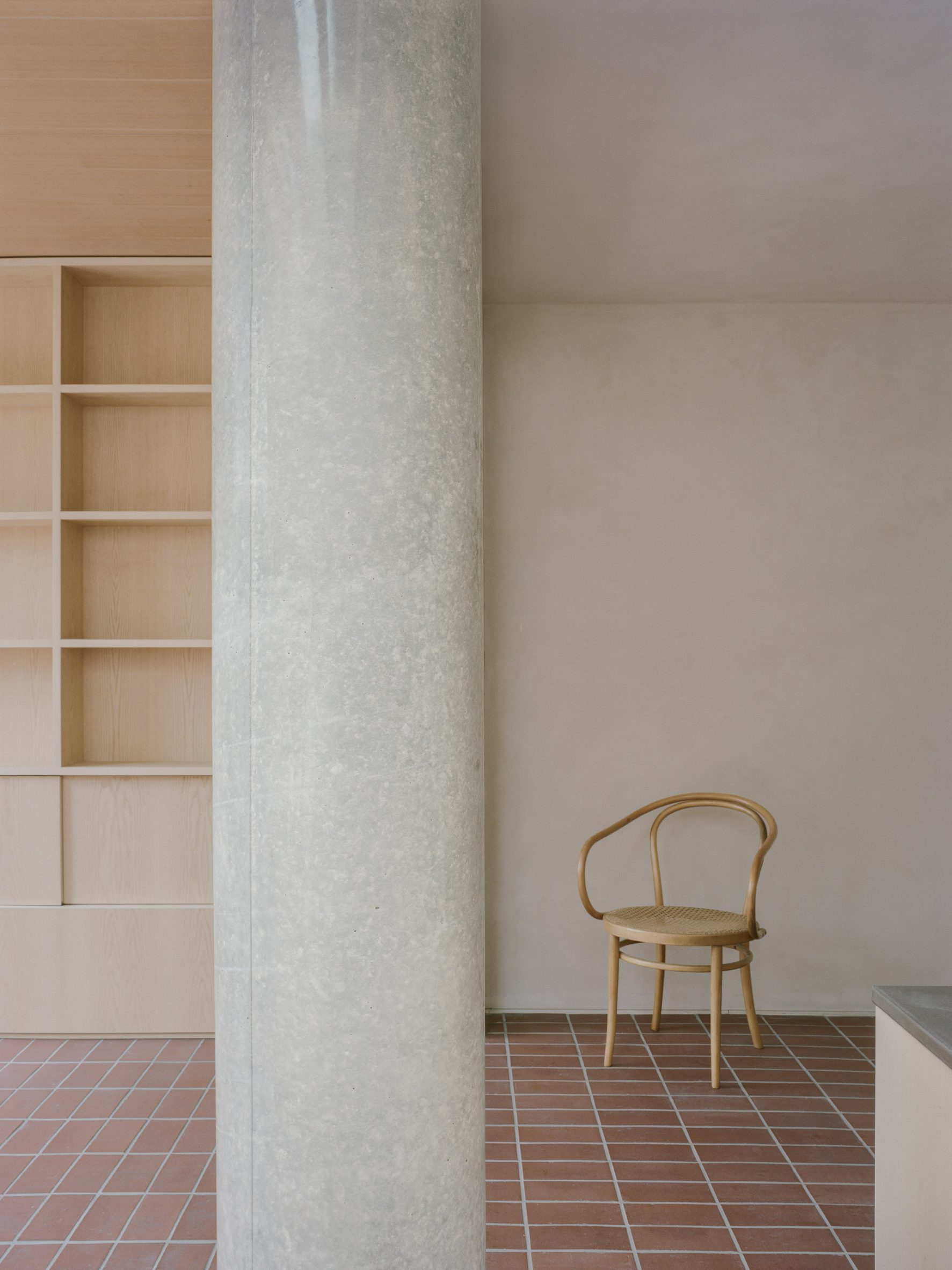 Concrete column and chair in Herne Hill House extension by TYPE