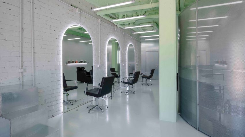 Row of black styling chairs in front of arched mirrors in Mood hair salon in Madrid by Casa Antillon