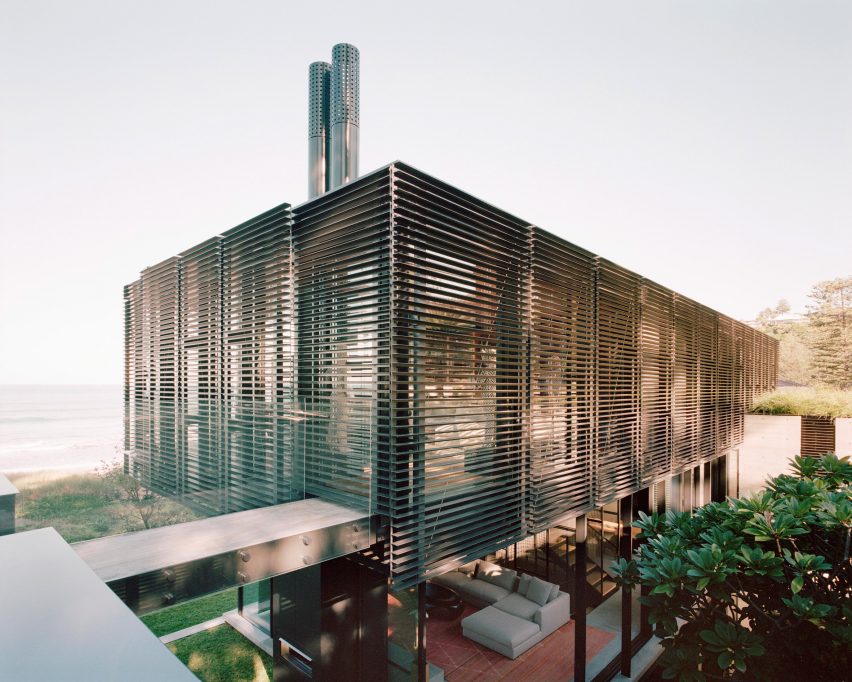 The upper level of Bilgola Beach House is wrapped in black slatted shutters
