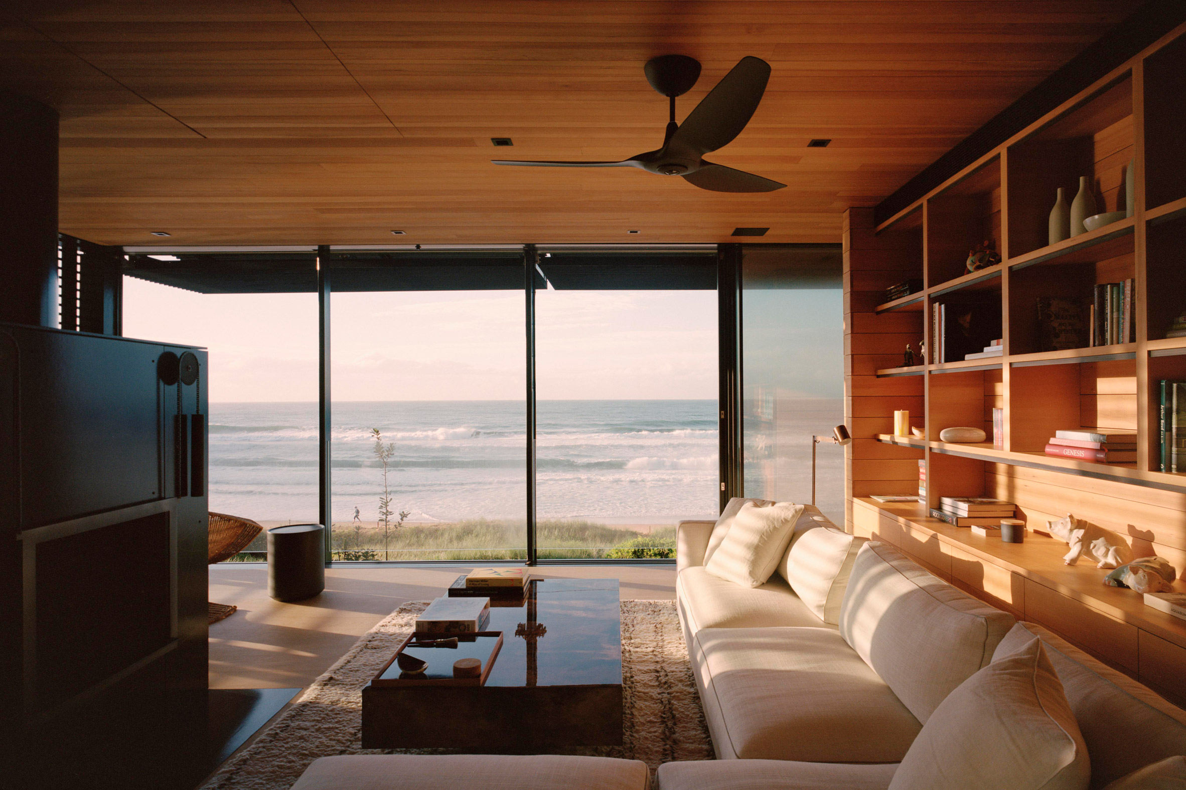 The living area has wooden interiors and a seafront view