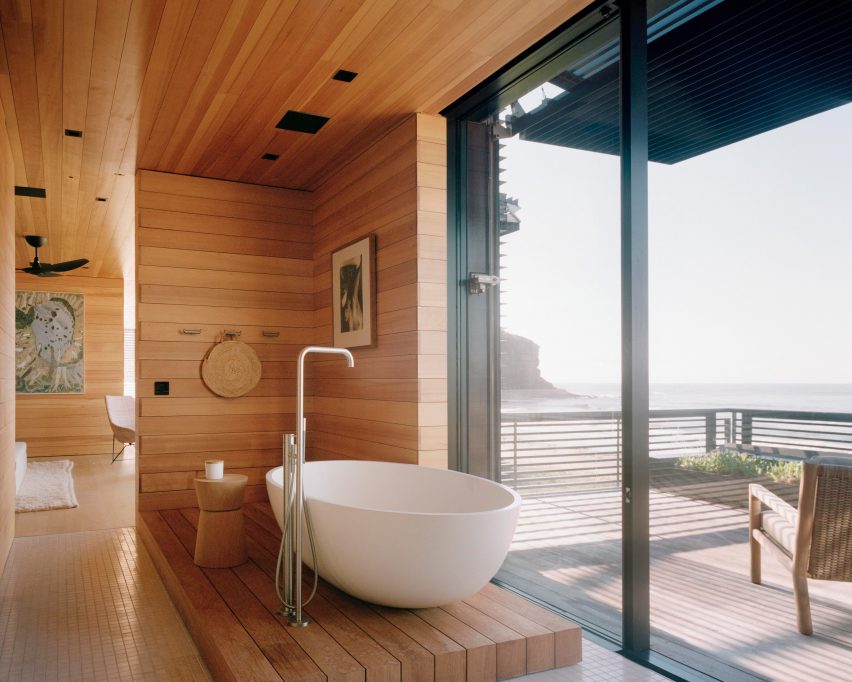 A free standing bath is pictured in a wood-lined bathroom