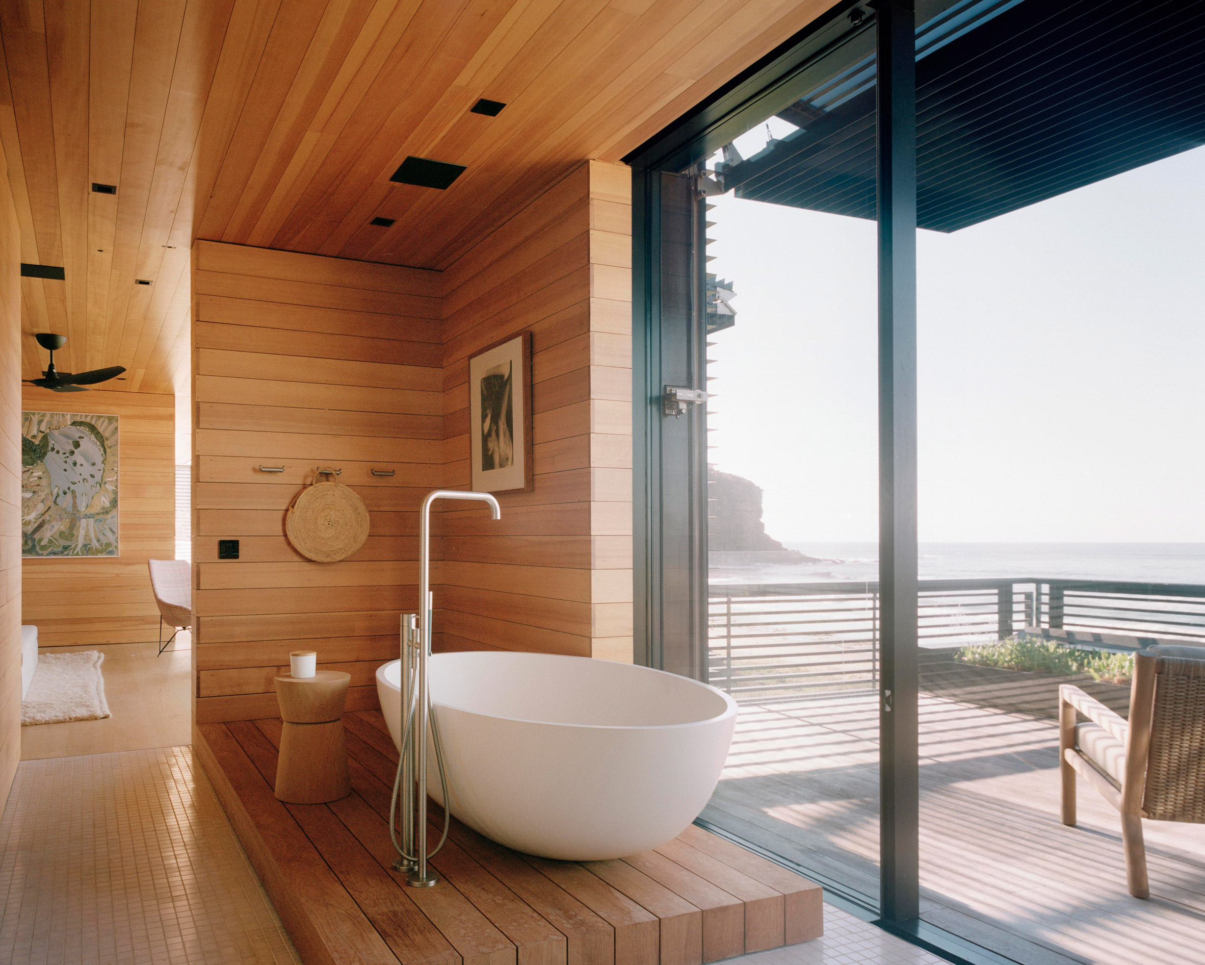 A free standing bath is pictured in a wood-lined bathroom