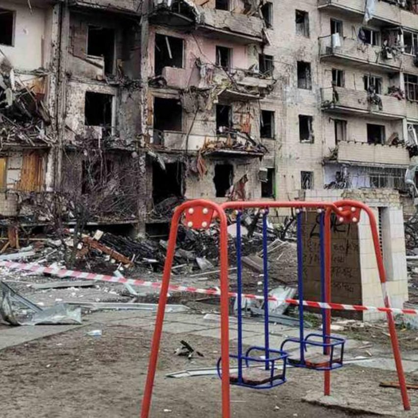 Red swing set in front of a Kyiv building damaged during the Russian invasion of Ukraine