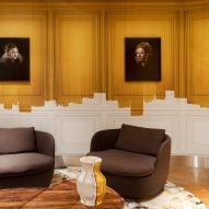 Brown armchairs in front of white and yellow painted wall with Dutch master replicas nin VIP centre of Schiphol airport, designed by Marcel Wanders