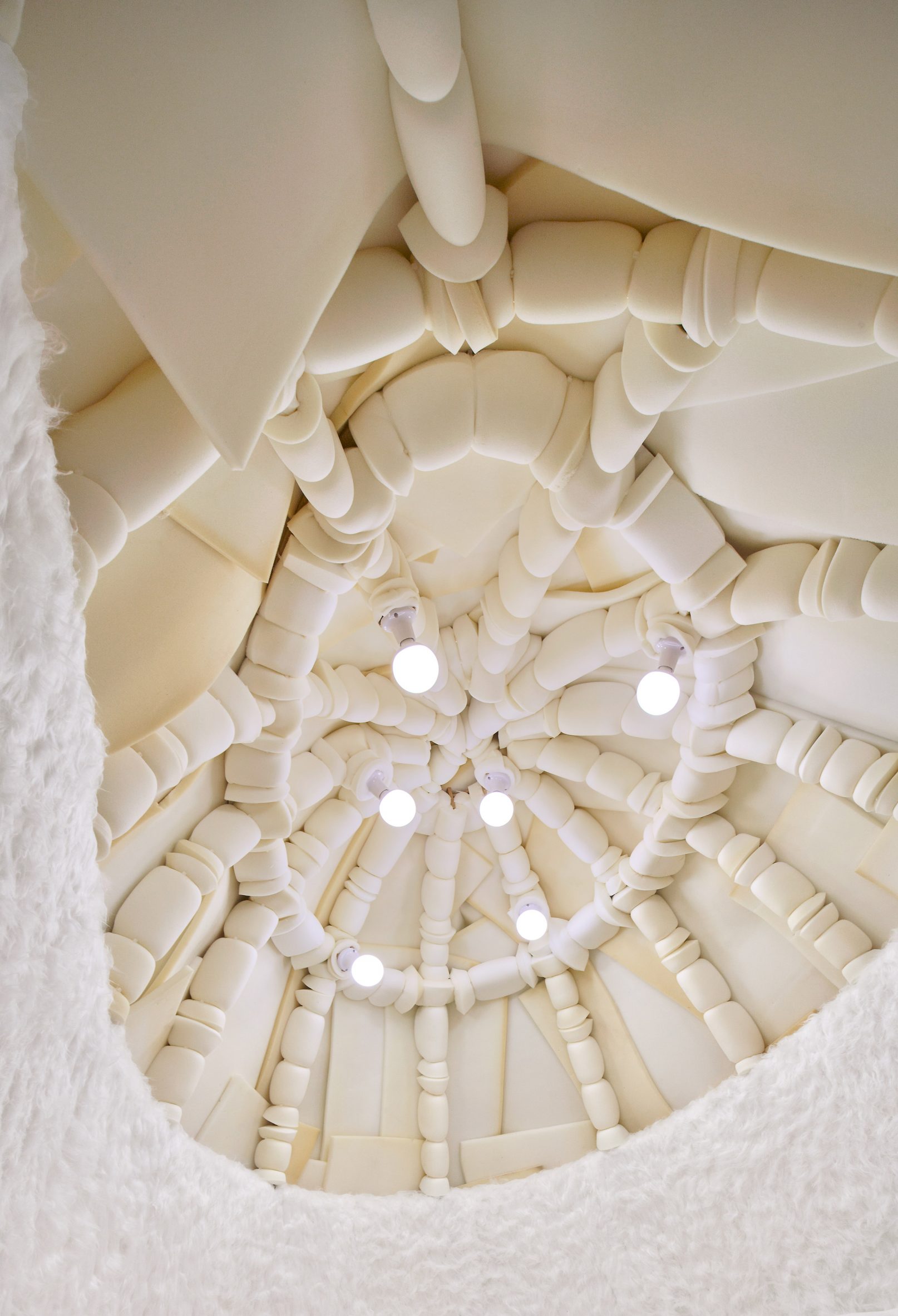 Foam-covered ceiling of winter bedroom with six bulb lights