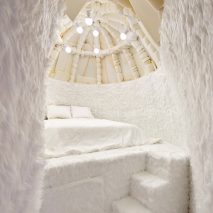 Interior of Winter Bedroom by Takk with foam-covered dome ceiling and bed on a raised platform covered by fluffy white carpet
