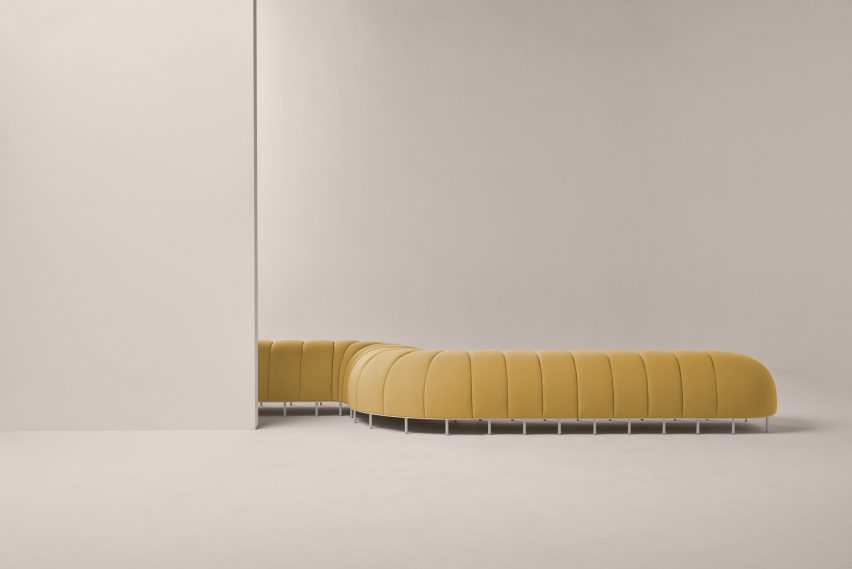 Yellow Worm chair winding around a wall