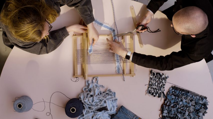 A photograph of two people making a new material from Levi jeans