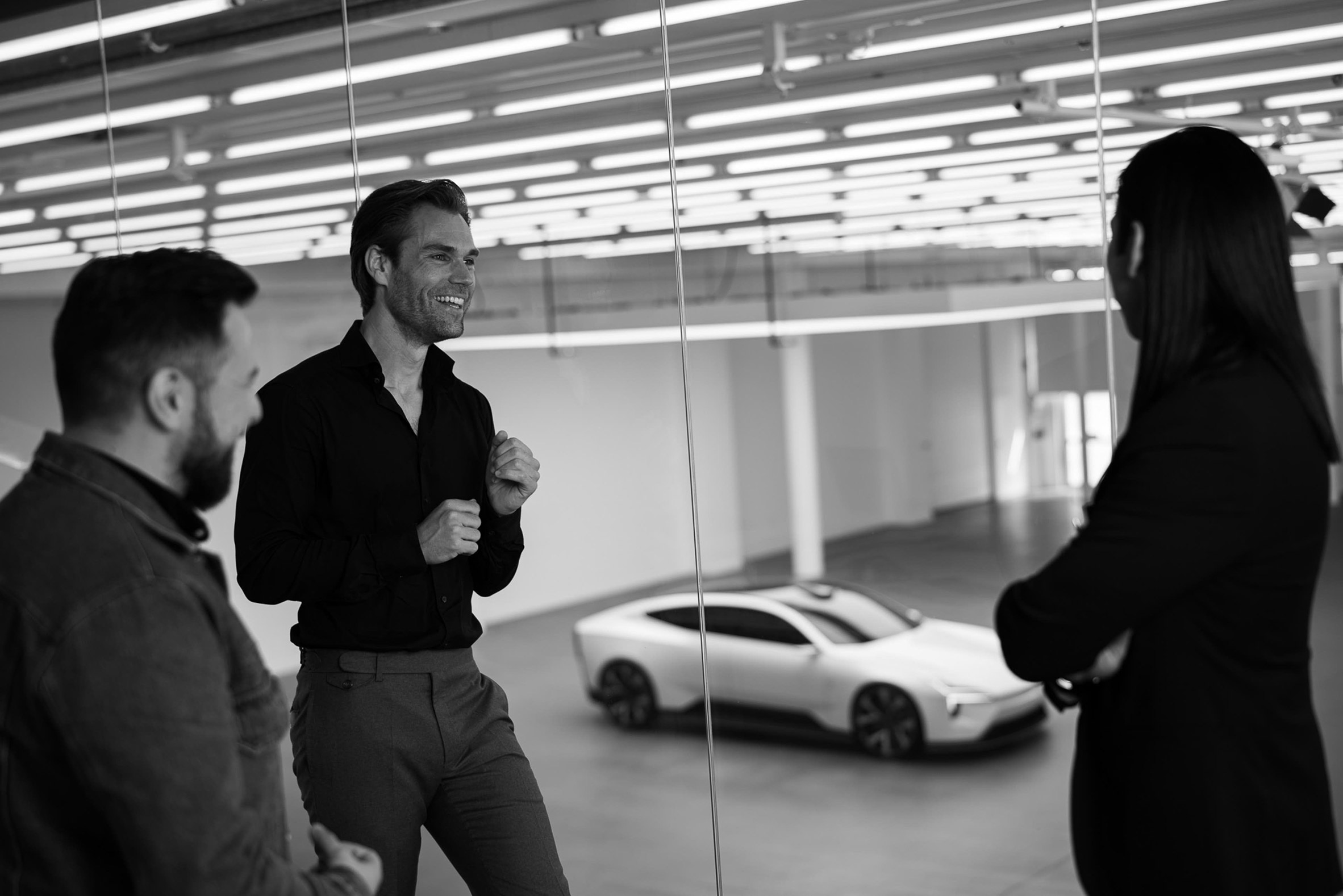 A photograph of people in front of a Polestar car