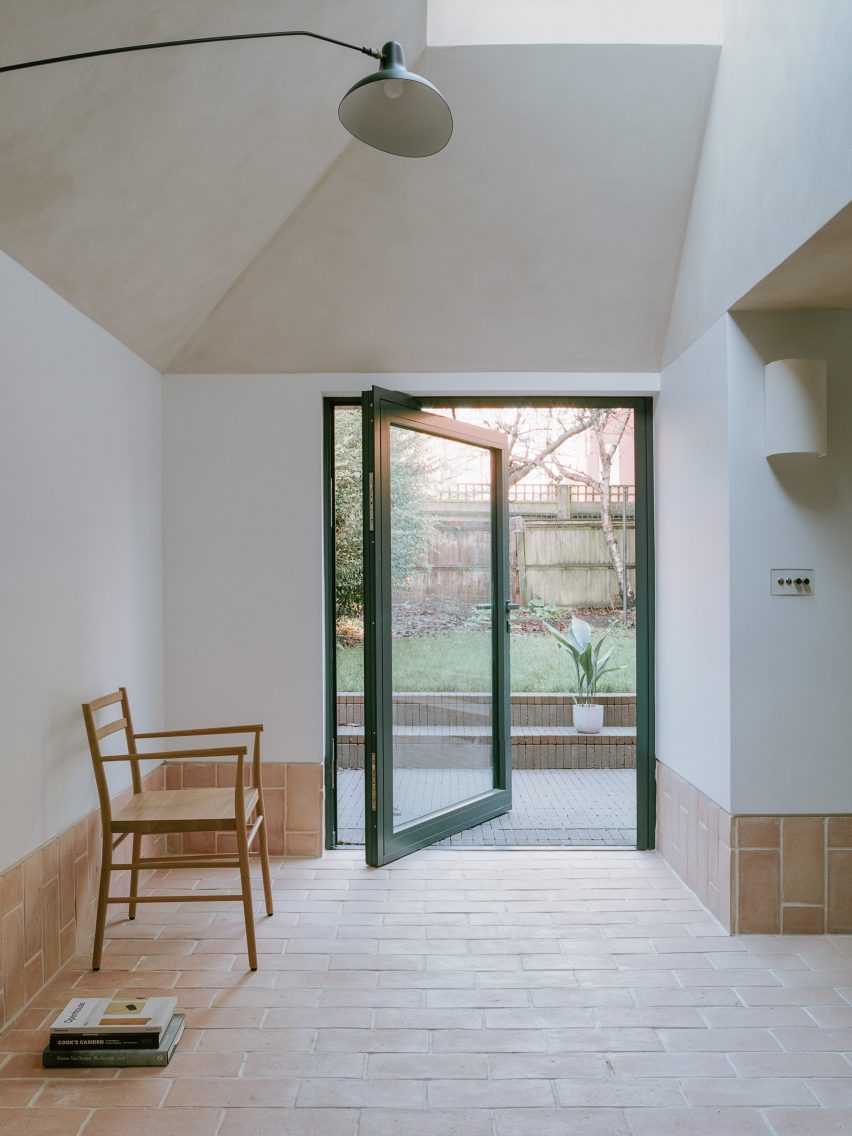 Pivoting glass door next to chair in home interior by Studio McW