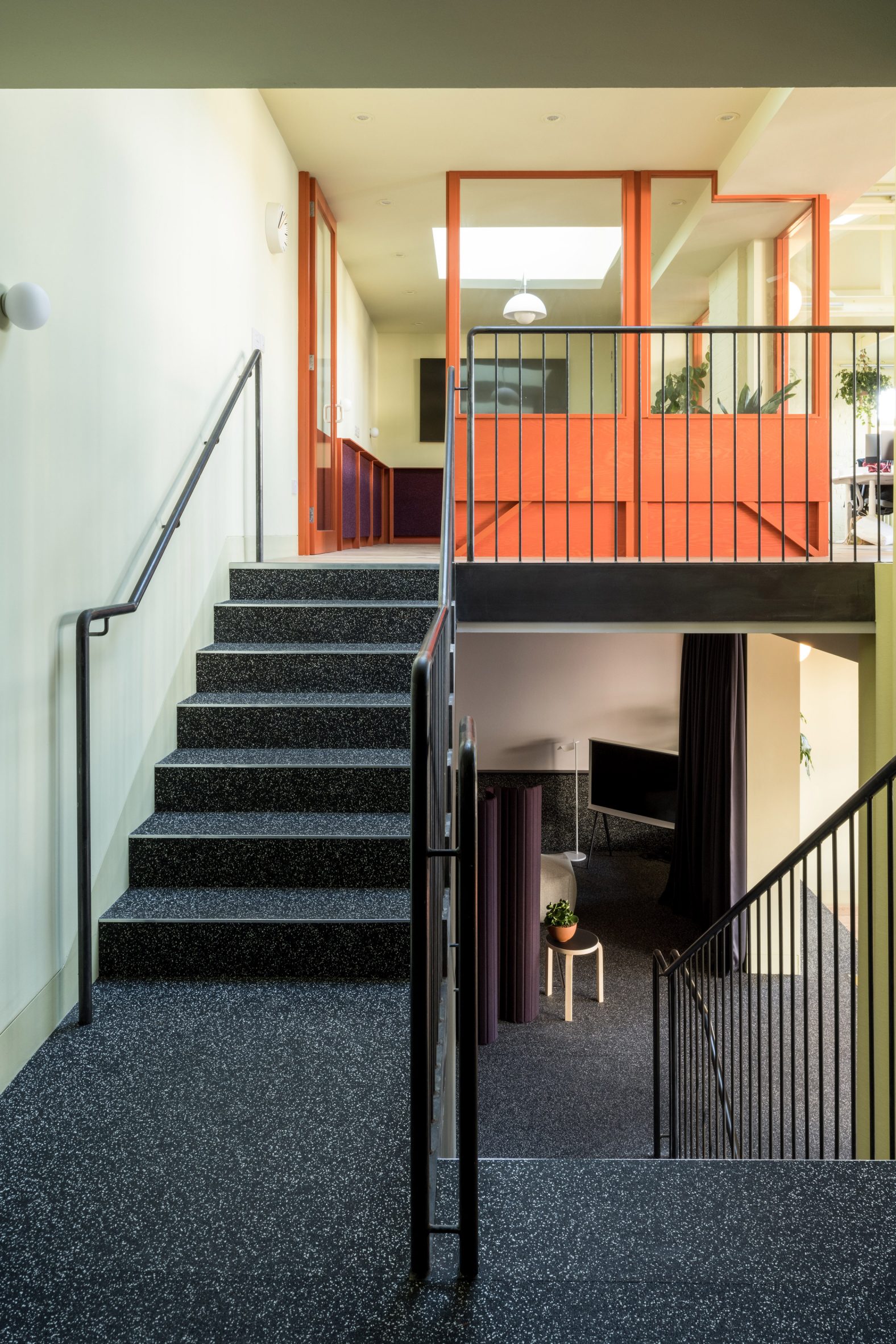 Recycled rubber staircase and red-painted meeting room partitions