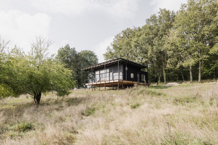 The wooden house was perched on a sloping hill