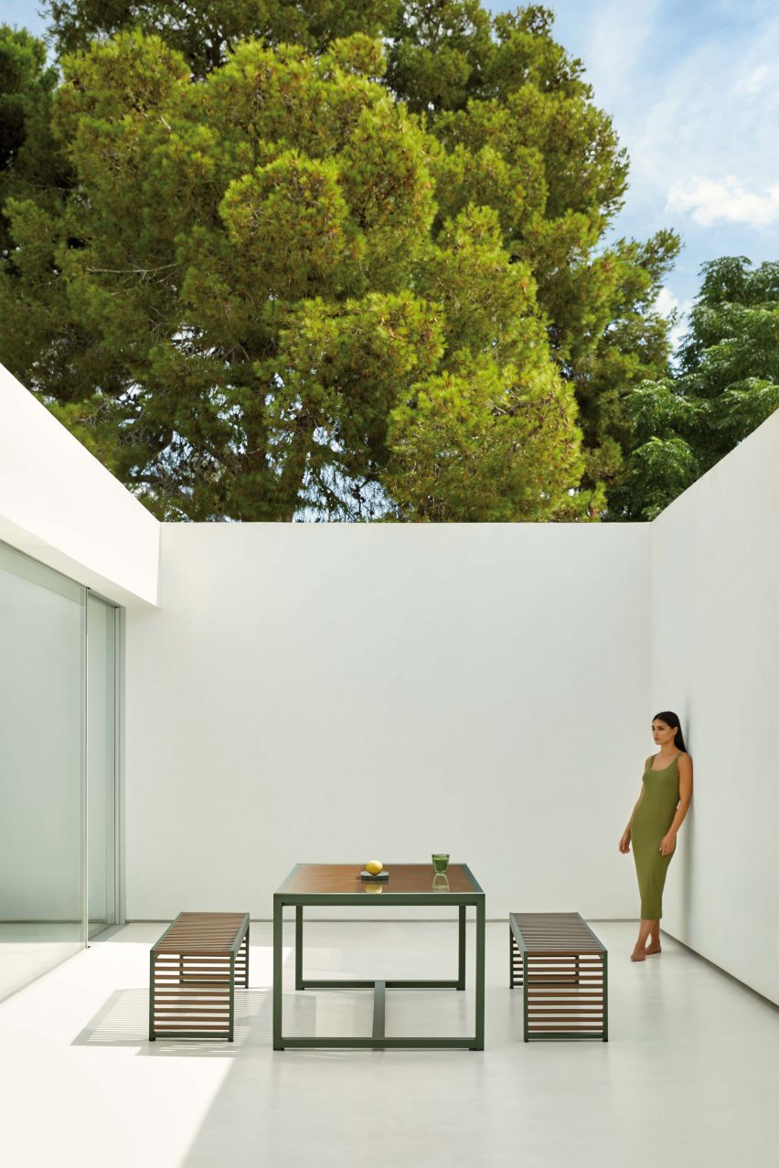 Bottle green dining table and benches in an outdoor setting