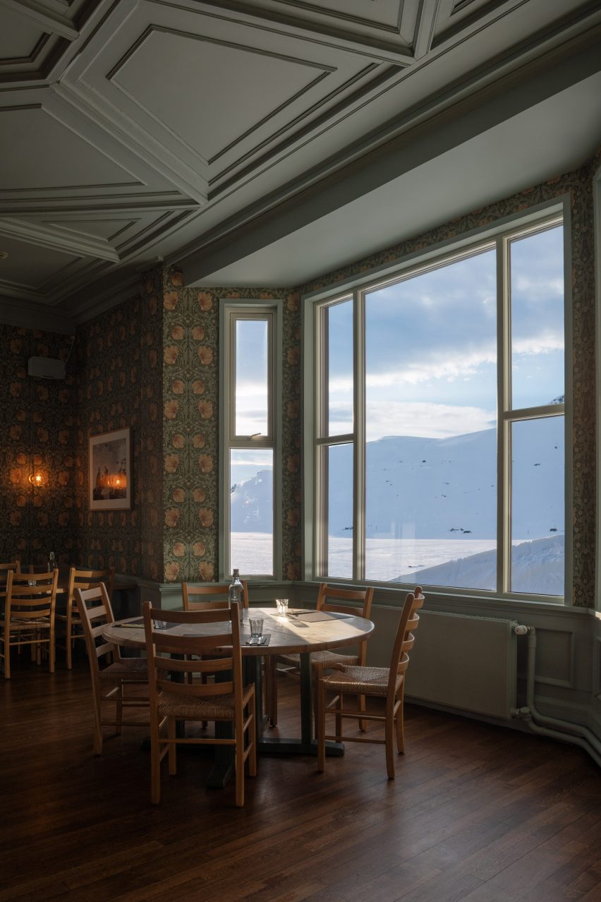 Hotel dining room by Snøhetta with floral wallpaper a wooden furniture