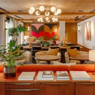 Lounge inside The Gessner apartments by Way of Life and Fettle with orange and beige seating and vibrant artwork