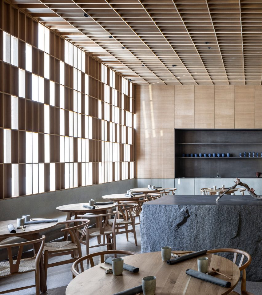 Gridded timber panels and granite counter in restaurant by Pitsou Kedem