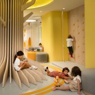 Sulkin Askenazi arranges yellow school interiors around wooden tree