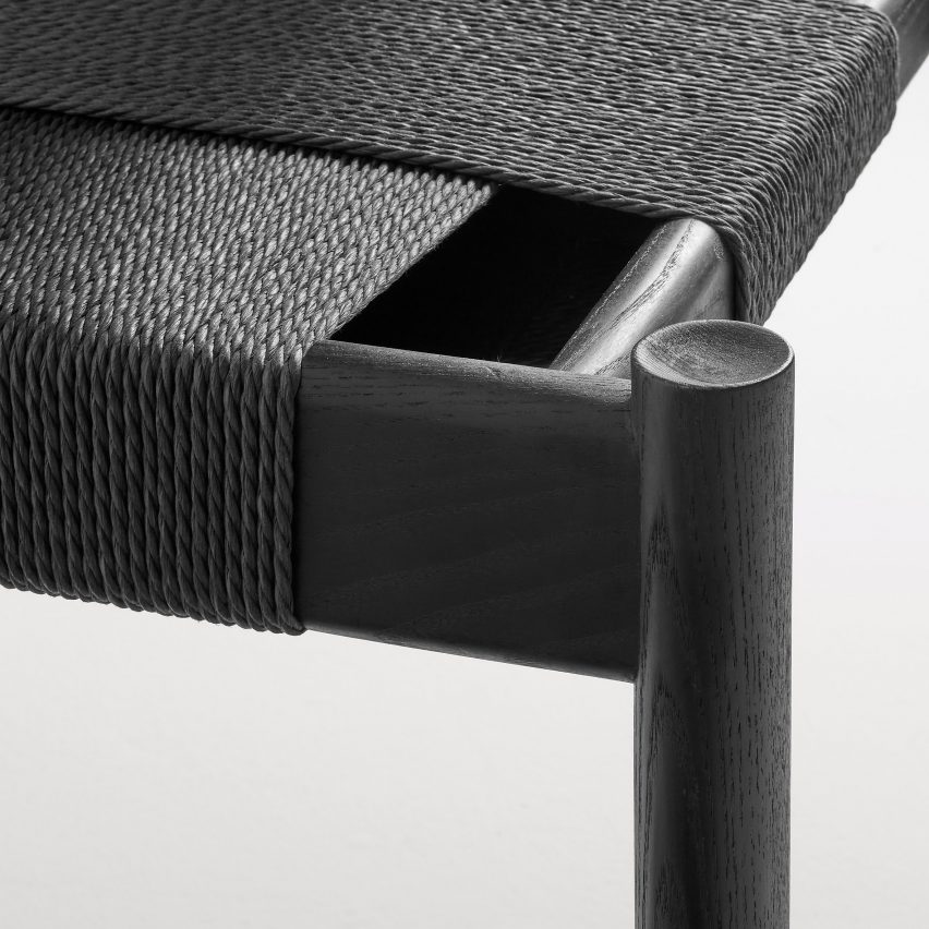 Close-up of black cord seat on black Invitation bench