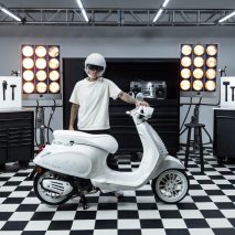Justin Bieber in a white helmet holding a scooter he designed for Vespa