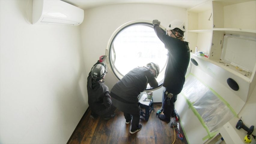 Image of workers dismantling the interior of the Nakagin Capsule Tower