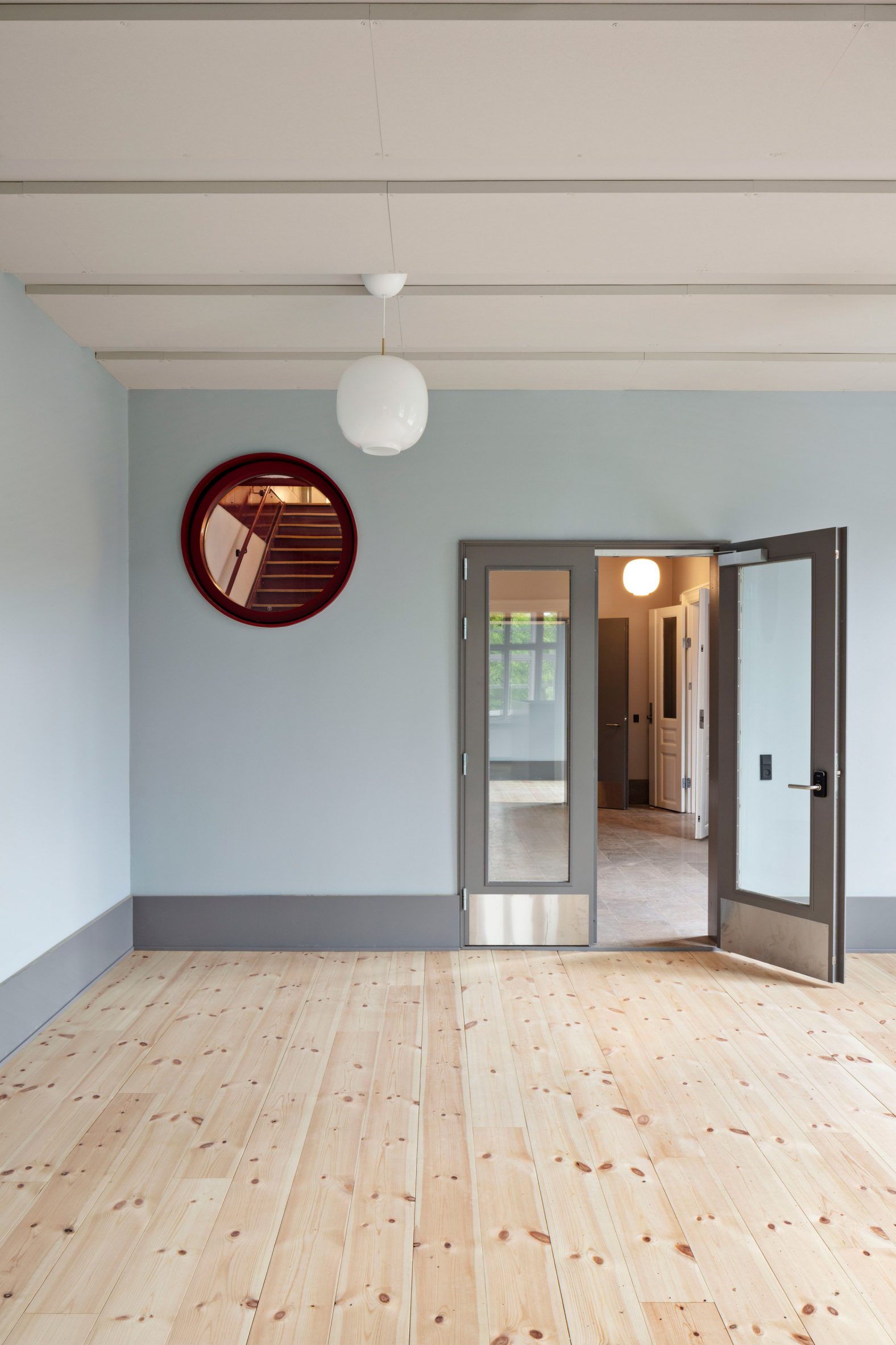 A shared space has blue painted walls and light wood floors