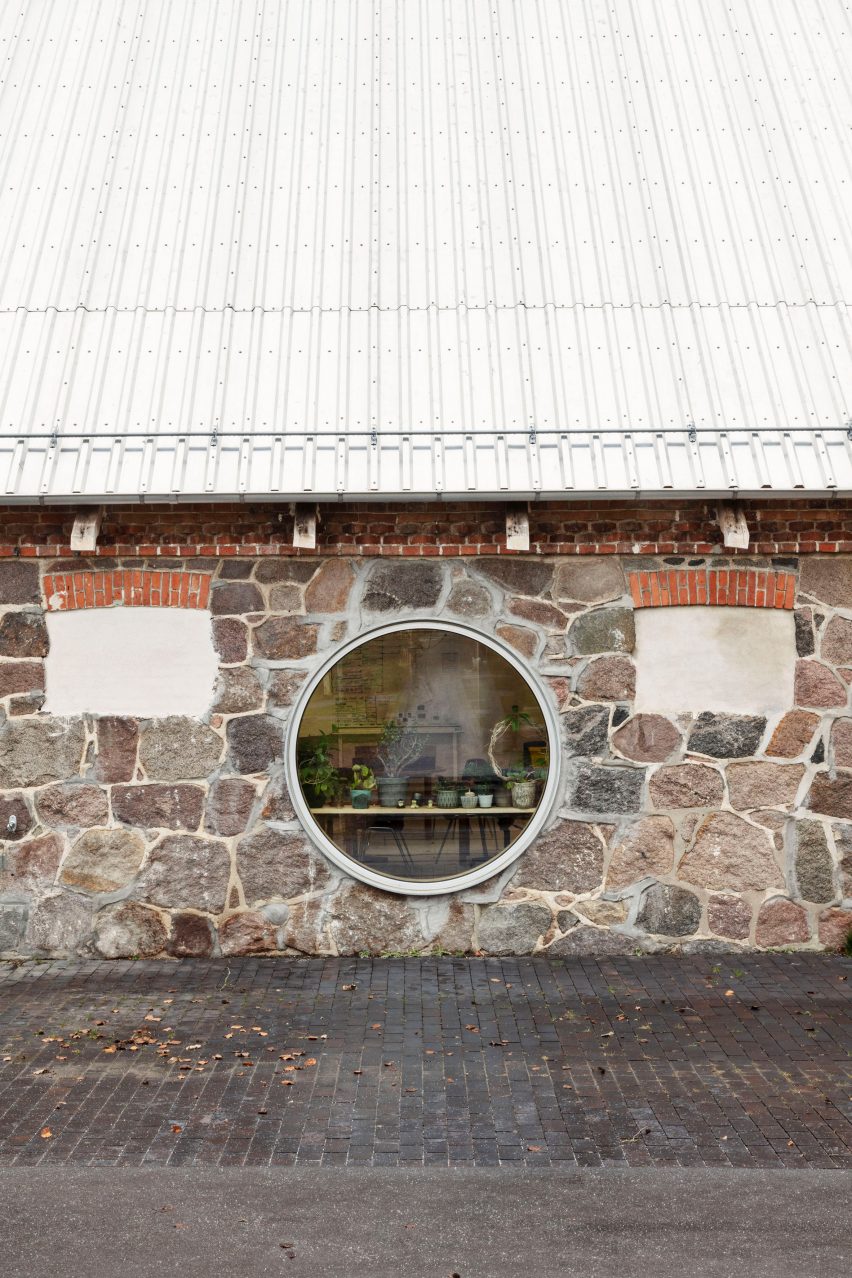 A circular window punctuates an original stone barn wall