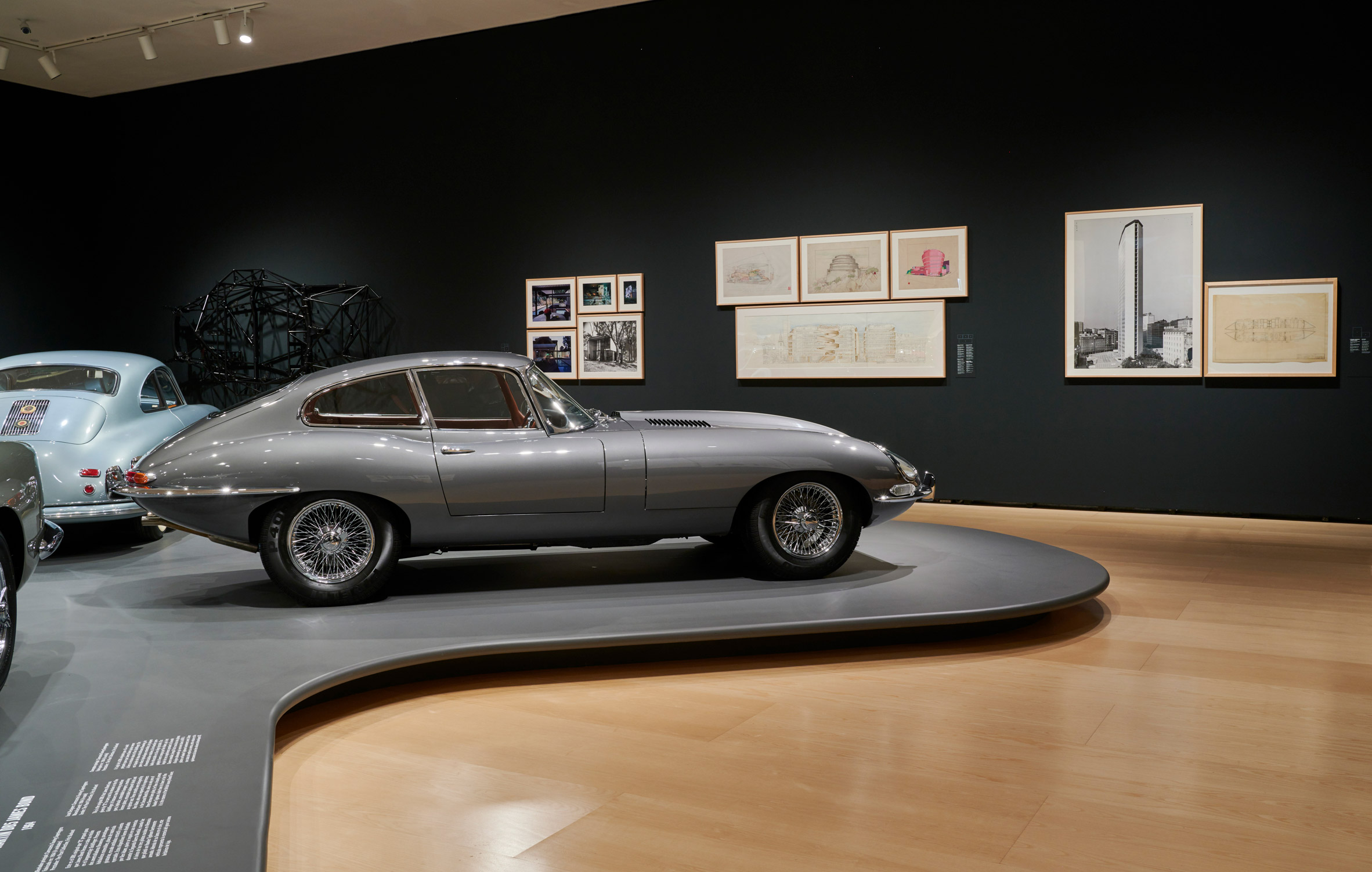 A silver car in a gallery room