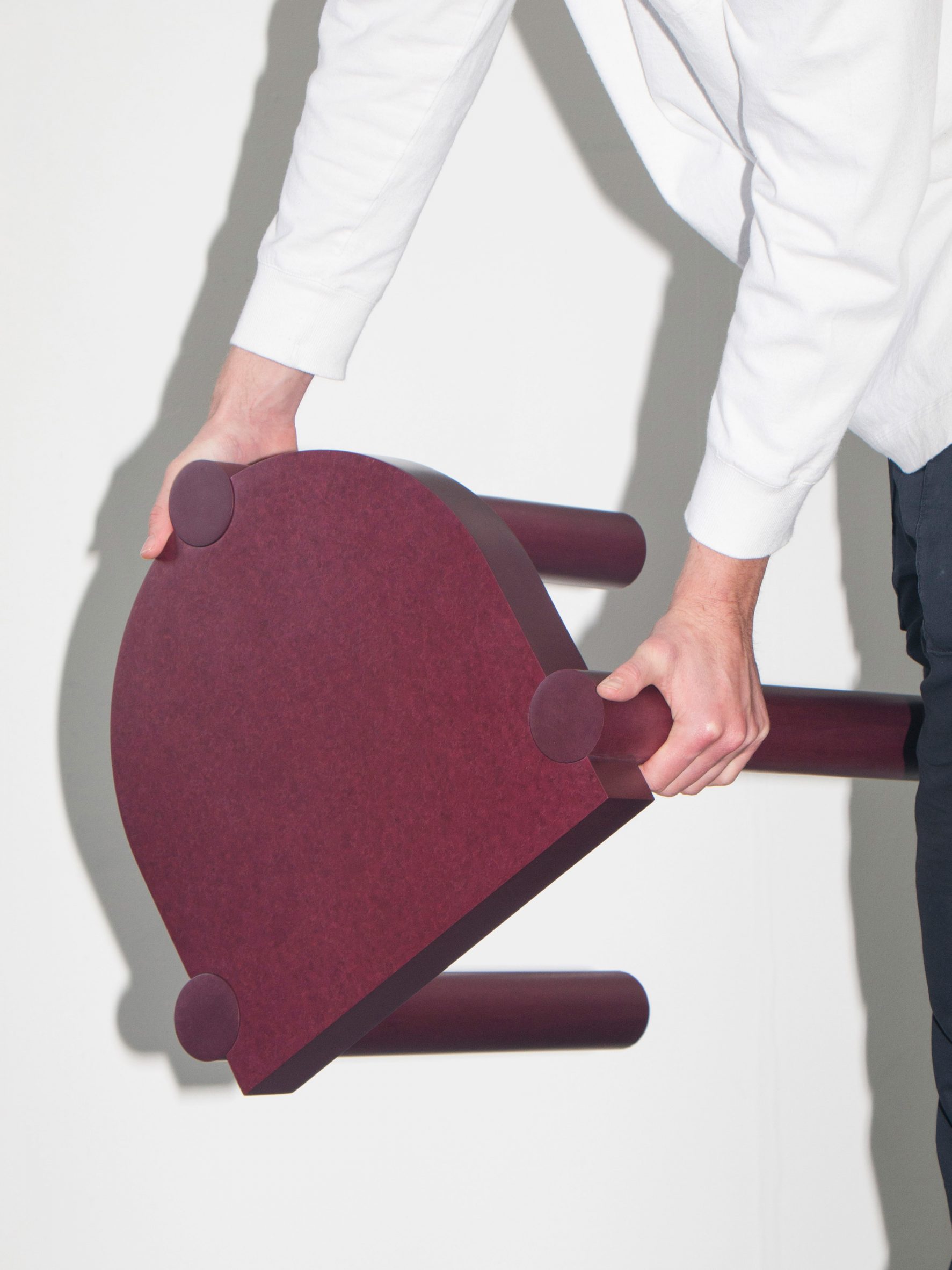 Man holding three-legged Plod stool made from recycled paper